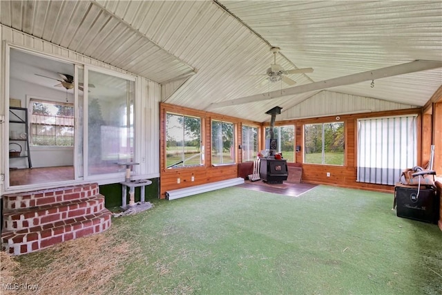 unfurnished sunroom with lofted ceiling, a baseboard heating unit, a wood stove, and ceiling fan