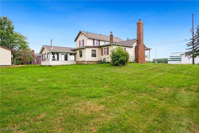 rear view of house featuring a yard