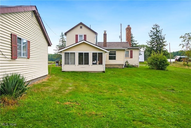 back of house featuring a yard and a chimney