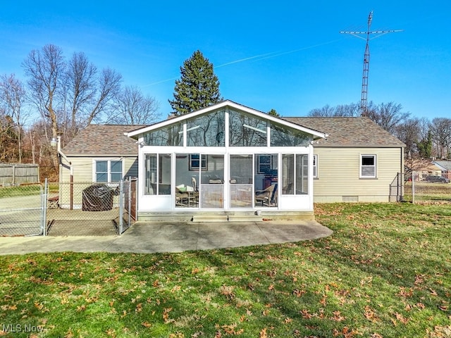 rear view of property featuring fence, roof with shingles, a lawn, a sunroom, and a patio area