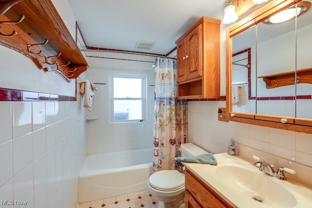 full bathroom with visible vents, toilet, shower / bath combo, tile walls, and vanity