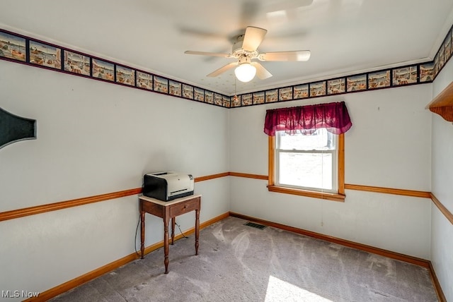 carpeted spare room with visible vents, baseboards, and ceiling fan