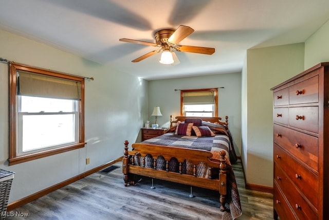 bedroom with visible vents, baseboards, dark wood-style floors, and a ceiling fan