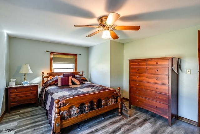 bedroom featuring baseboards, ceiling fan, and dark wood-style flooring