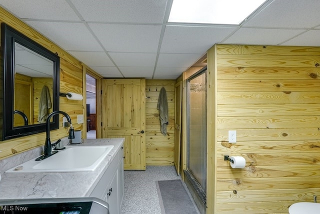 laundry room with laundry area, wood walls, and a sink