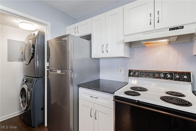 kitchen with stacked washer / dryer, under cabinet range hood, freestanding refrigerator, electric range, and white cabinetry