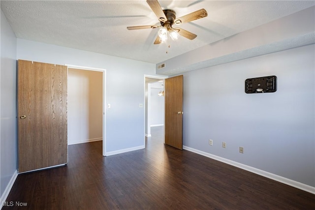 unfurnished bedroom featuring ceiling fan, baseboards, a textured ceiling, and wood finished floors