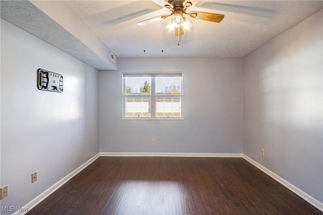 empty room with a textured ceiling, a ceiling fan, baseboards, and wood-type flooring