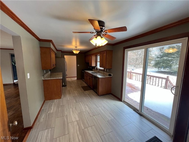 kitchen with brown cabinets, ornamental molding, a ceiling fan, a sink, and baseboards