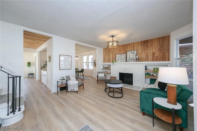 living area with a fireplace, wooden walls, and light wood-style floors