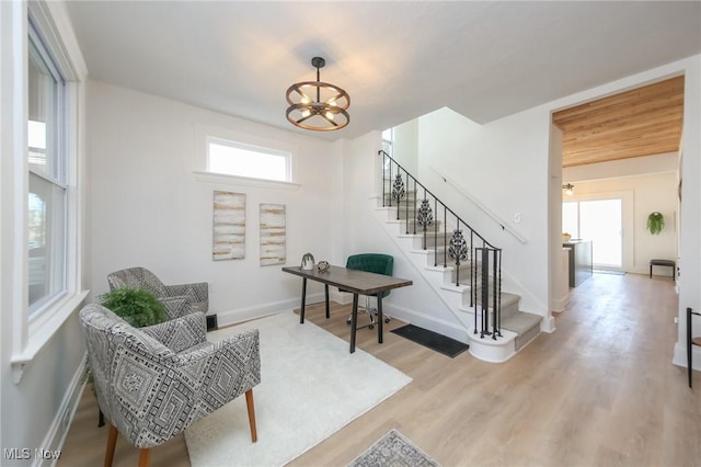 interior space featuring stairway, baseboards, an inviting chandelier, and wood finished floors