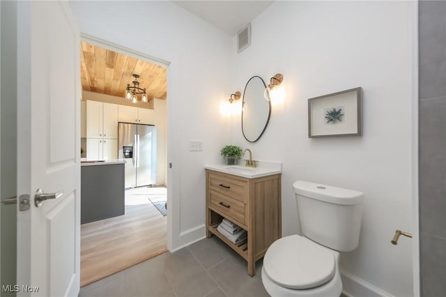 bathroom featuring vanity, baseboards, visible vents, tile patterned floors, and toilet