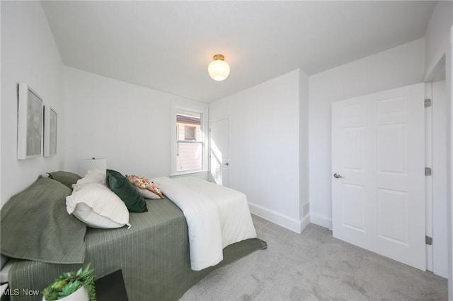 bedroom with baseboards and light carpet