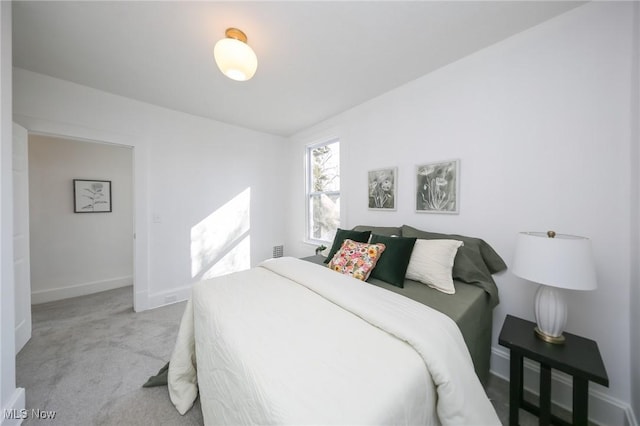 bedroom with light colored carpet and baseboards