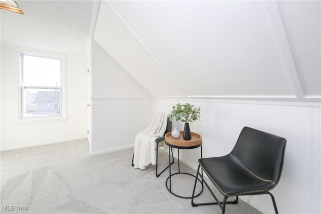 living area featuring carpet and vaulted ceiling