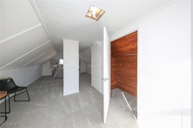 bonus room featuring carpet flooring, wood walls, and vaulted ceiling