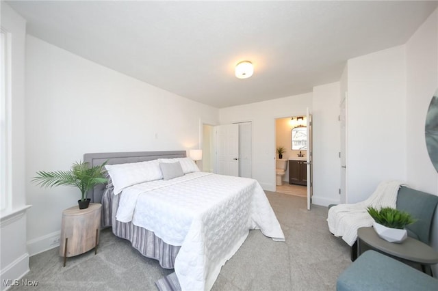 bedroom featuring baseboards, light carpet, a closet, and connected bathroom