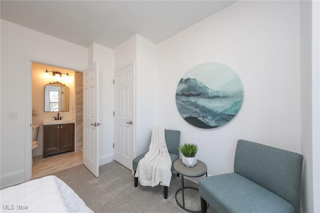 sitting room featuring baseboards and light carpet