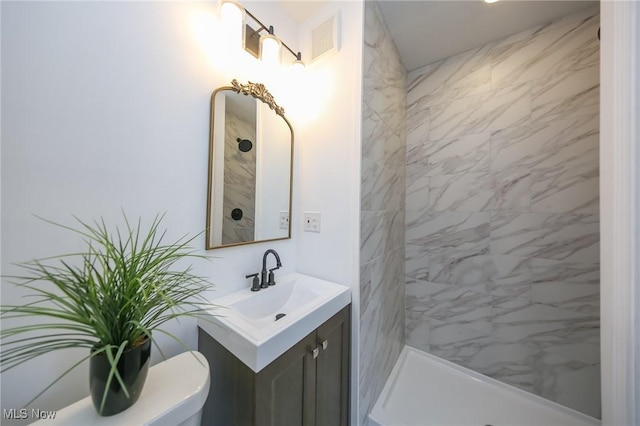 bathroom with vanity, toilet, visible vents, and tiled shower