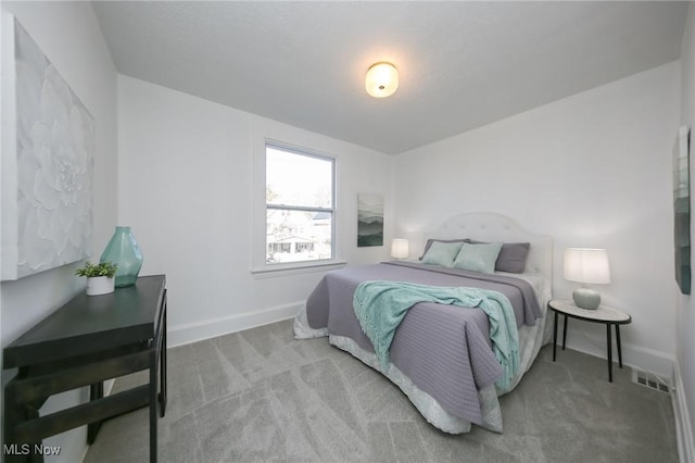 carpeted bedroom with visible vents and baseboards