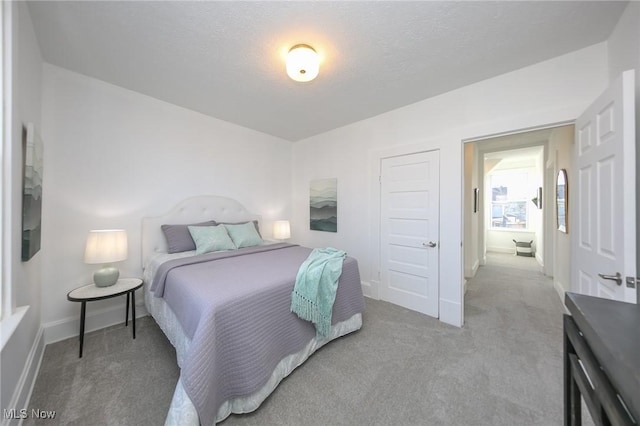 bedroom featuring carpet flooring, baseboards, and a textured ceiling