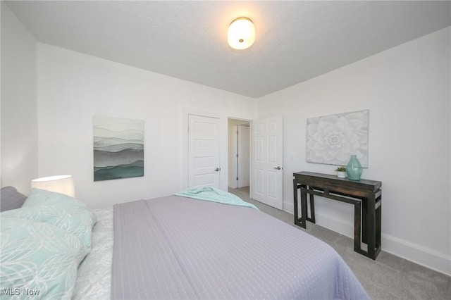 bedroom with baseboards and carpet floors