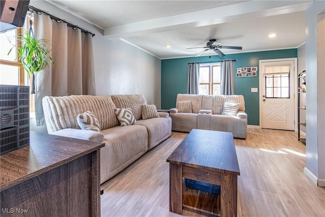 living area featuring light wood finished floors, baseboards, crown molding, and ceiling fan