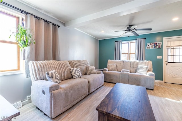 living room with beam ceiling, plenty of natural light, and light wood-style flooring