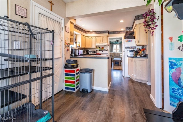 kitchen with dark wood-type flooring, range, dark countertops, and under cabinet range hood