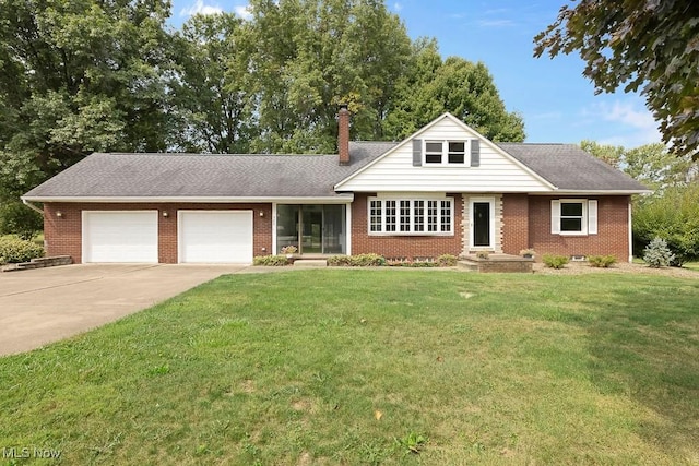 view of front of house with brick siding, a front yard, a chimney, a garage, and driveway