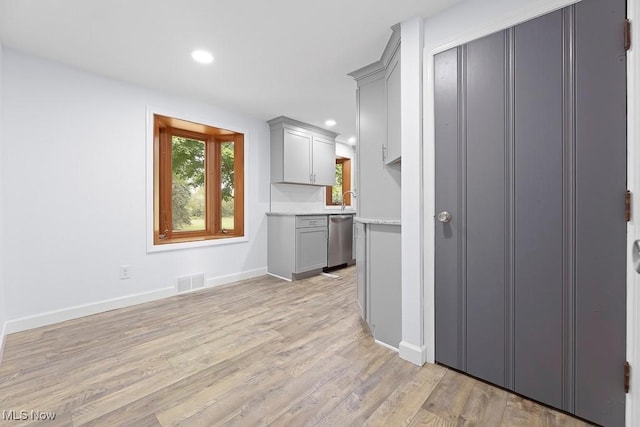 kitchen with visible vents, gray cabinetry, light wood-style floors, and stainless steel dishwasher