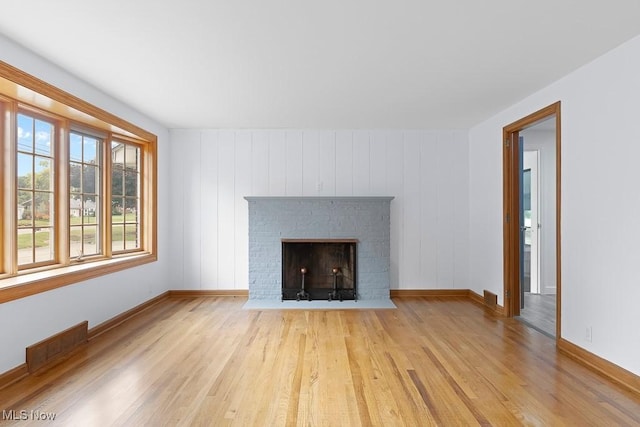 unfurnished living room with visible vents, light wood-style flooring, a fireplace, and baseboards