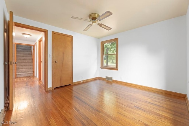 unfurnished bedroom with visible vents, wood finished floors, a closet, baseboards, and ceiling fan