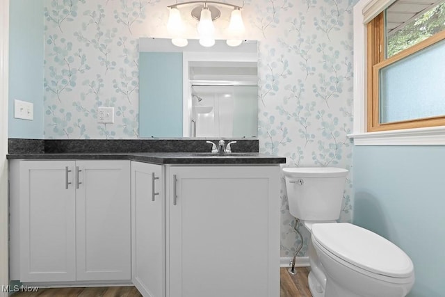 full bathroom featuring toilet, vanity, and wallpapered walls