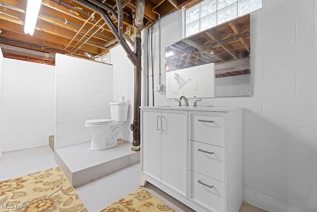 full bath with a tile shower, concrete floors, toilet, and vanity