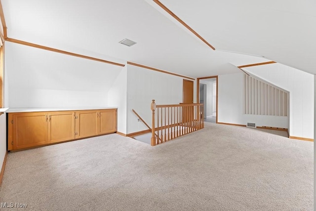 additional living space with vaulted ceiling, visible vents, and carpet floors