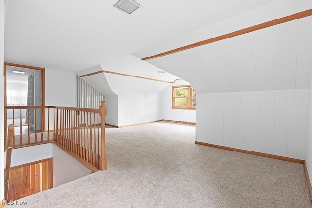 additional living space with vaulted ceiling, carpet, visible vents, and baseboards