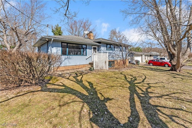 view of front of property with a front yard, a chimney, and a shingled roof