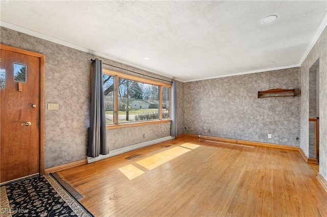 interior space featuring baseboards, wood finished floors, and crown molding