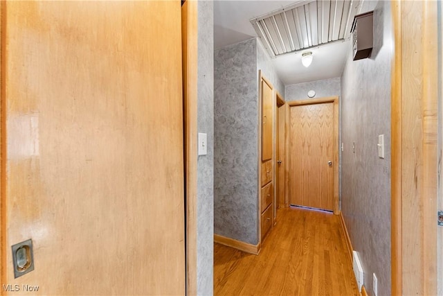 hall featuring attic access and wood finished floors