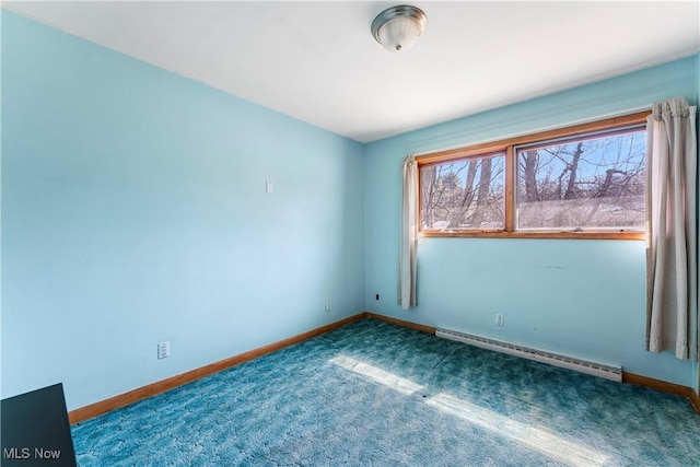 carpeted spare room with a baseboard heating unit, plenty of natural light, and baseboards