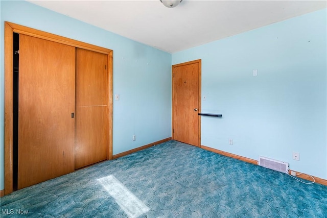 unfurnished bedroom with visible vents, baseboards, a closet, and carpet flooring