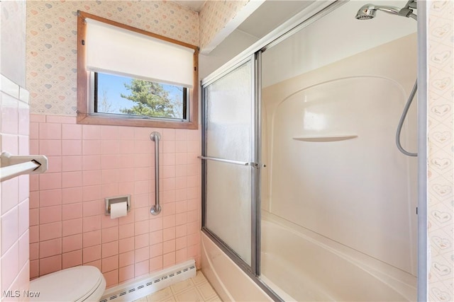 full bath with wallpapered walls, a baseboard heating unit, a wainscoted wall, toilet, and tile walls