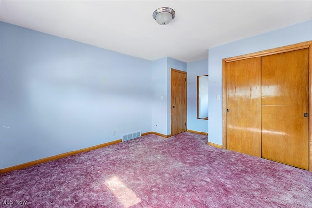 unfurnished bedroom featuring visible vents, baseboards, carpet floors, and a closet