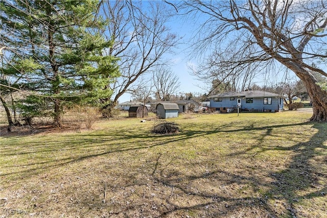 view of yard featuring a storage shed and an outbuilding