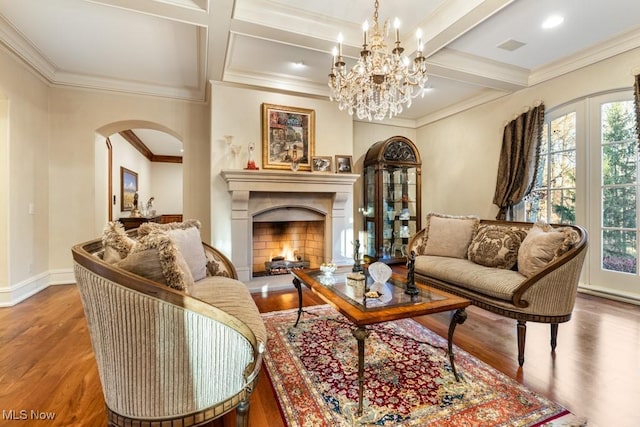 living area featuring arched walkways, a healthy amount of sunlight, and wood finished floors