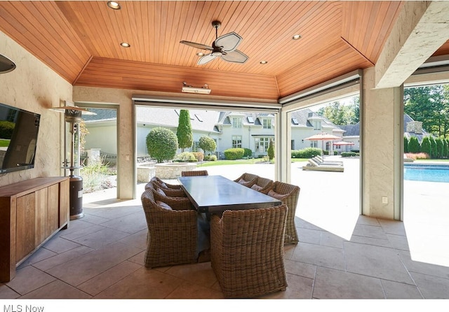 view of patio / terrace featuring outdoor dining space, an outdoor pool, and a ceiling fan