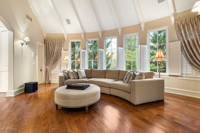 living area with visible vents, beam ceiling, high vaulted ceiling, wood finished floors, and baseboards