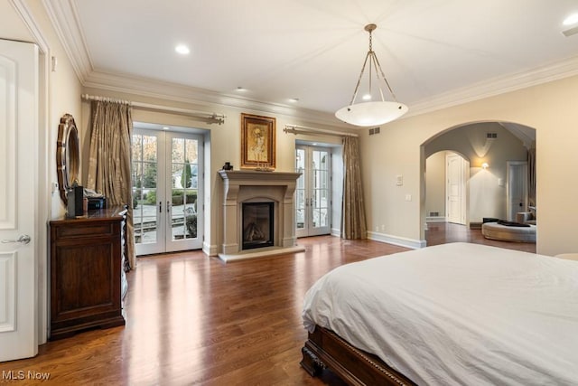 bedroom featuring access to exterior, ornamental molding, french doors, wood finished floors, and arched walkways