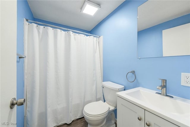 bathroom with vanity, a shower with shower curtain, toilet, and wood finished floors